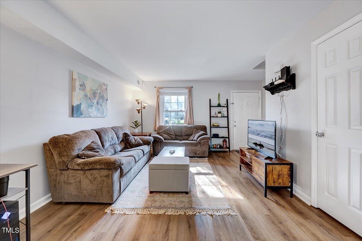 4808 Blue Bird Court, Unit D Raleigh, NC 27606 - Photo 3 of 31 a living room with furniture and a wooden floor