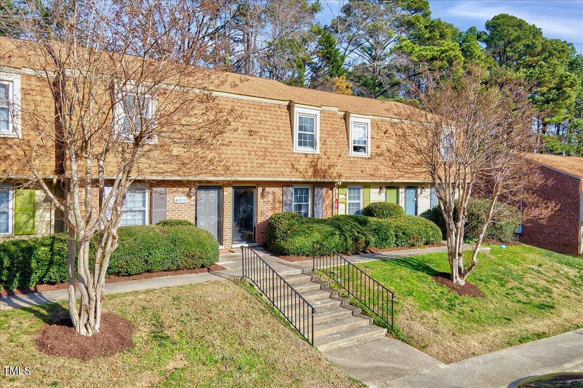 4808 Blue Bird Court, Unit D Raleigh, NC 27606 - Photo 31 of 31 a front view of a house with a yard and potted plants