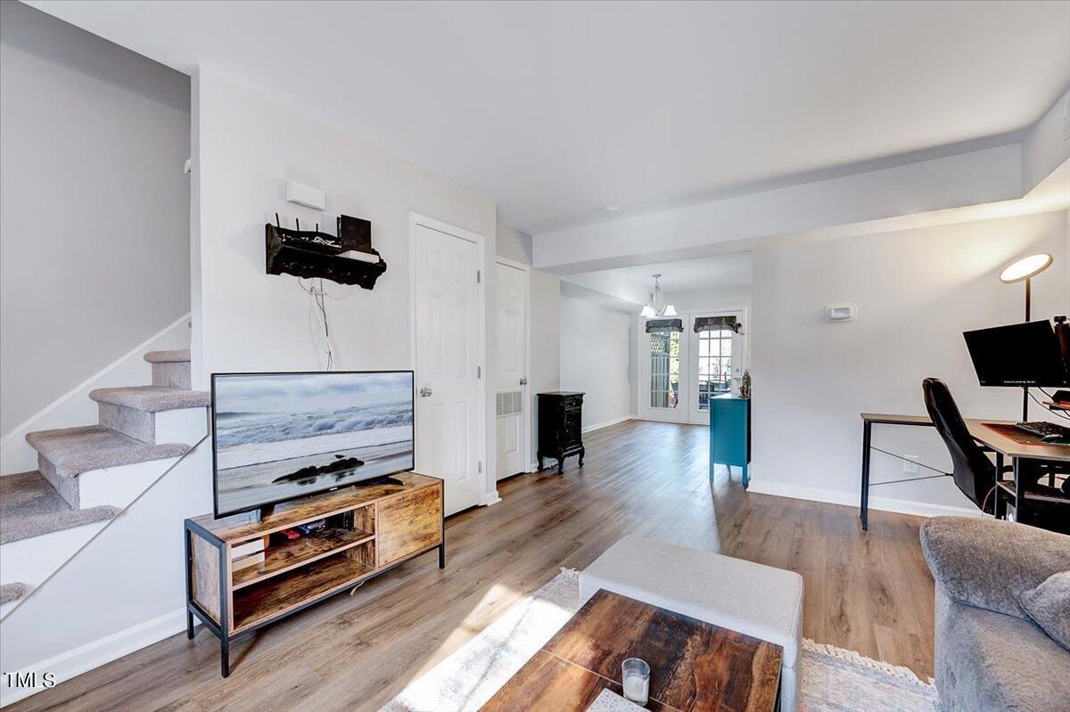 4808 Blue Bird Court, Unit D Raleigh, NC 27606 - Photo 10 of 31 a living room with furniture a flat screen tv and a wall painting