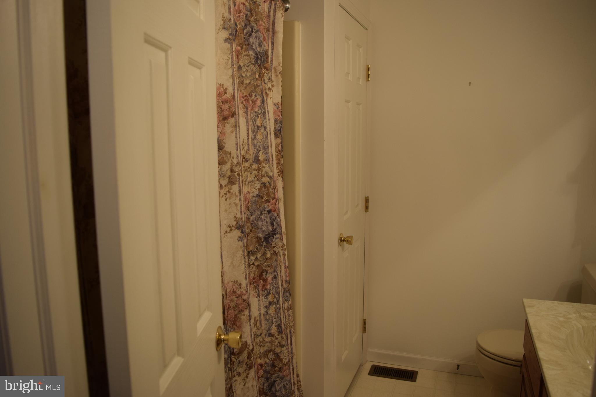 64 Cross Road Berkeley Springs, WV 25411 - Photo 22 of 30 a bathroom with a shower curtain and a toilet
