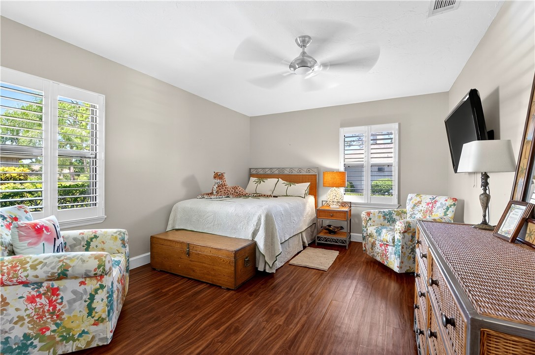 725 Timber Ridge Trail Southwest, Unit B Vero Beach, FL 32962 - Photo 13 of 27 a bedroom with a bed and wooden floor