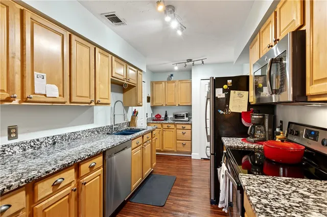 a kitchen with stainless steel appliances granite countertop a sink and cabinets