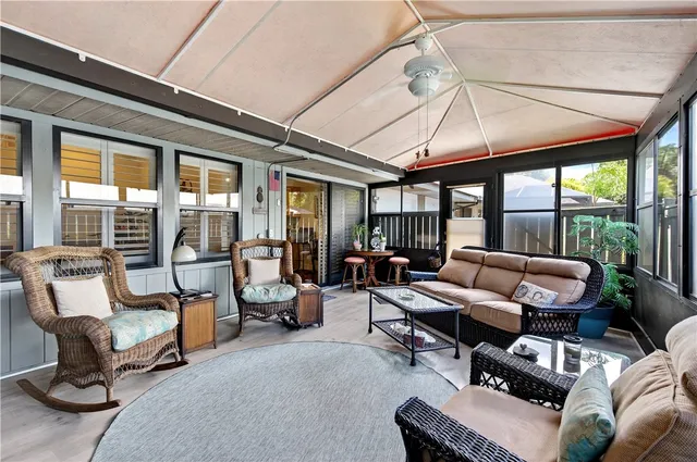 a living room with furniture and floor to ceiling windows