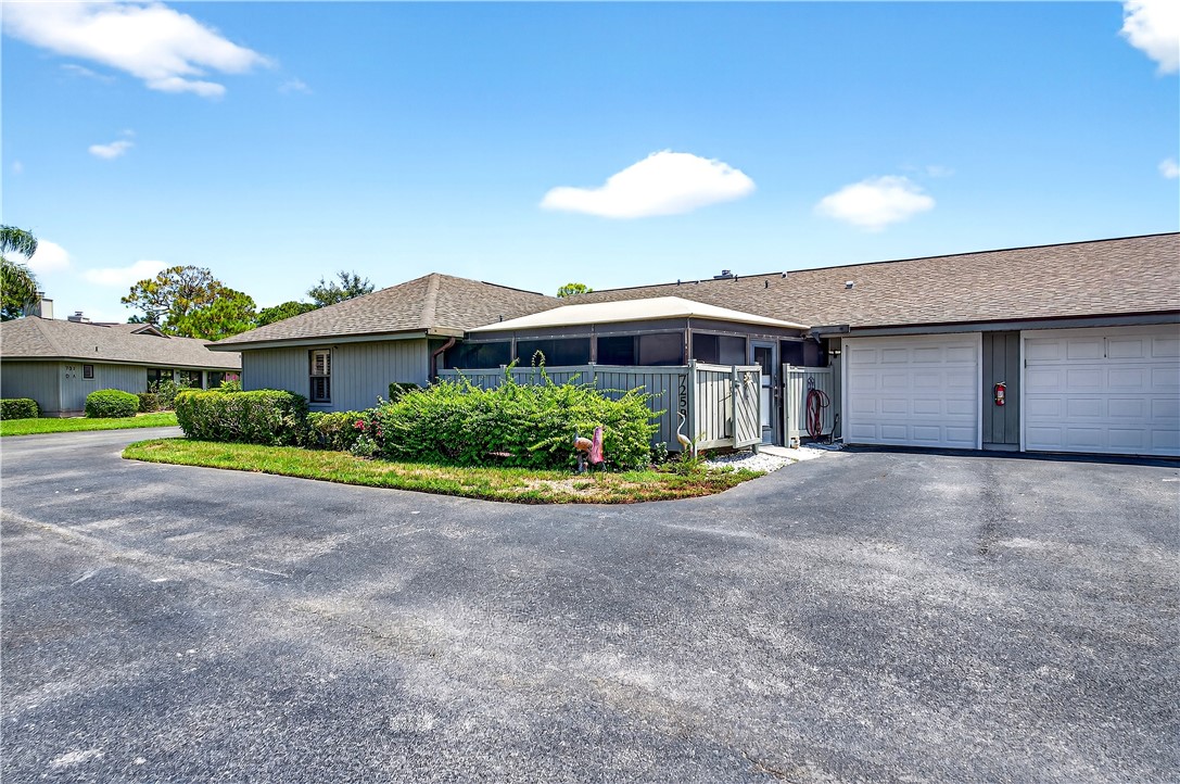 725 Timber Ridge Trail Southwest, Unit B Vero Beach, FL 32962 - Photo 19 of 27 a view of a house with a yard and potted plants