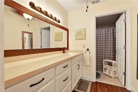 a spacious bathroom with a sink a mirror and a shower