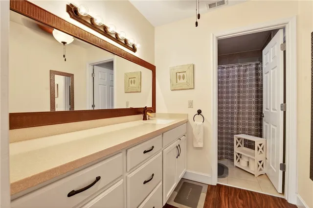a spacious bathroom with a sink a mirror and a shower