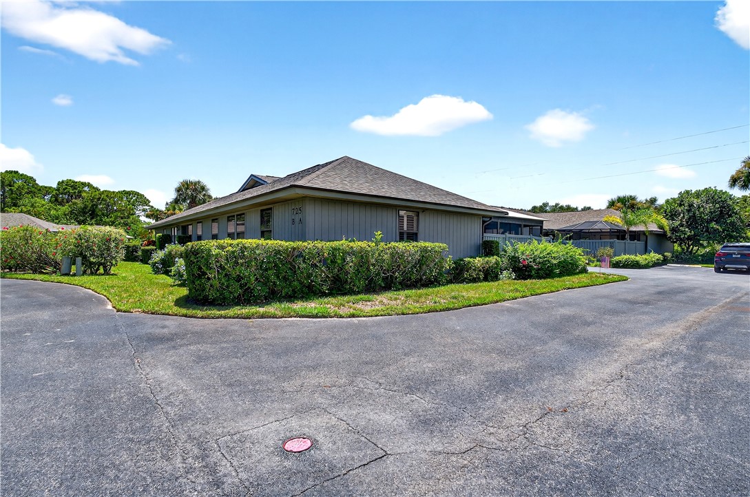 725 Timber Ridge Trail Southwest, Unit B Vero Beach, FL 32962 - Photo 28 of 36 a view of a house with a yard and potted plants