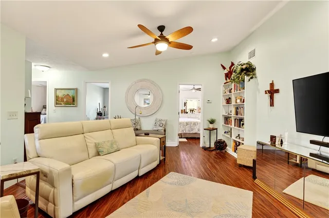 a living room with furniture and a flat screen tv with wooden floor