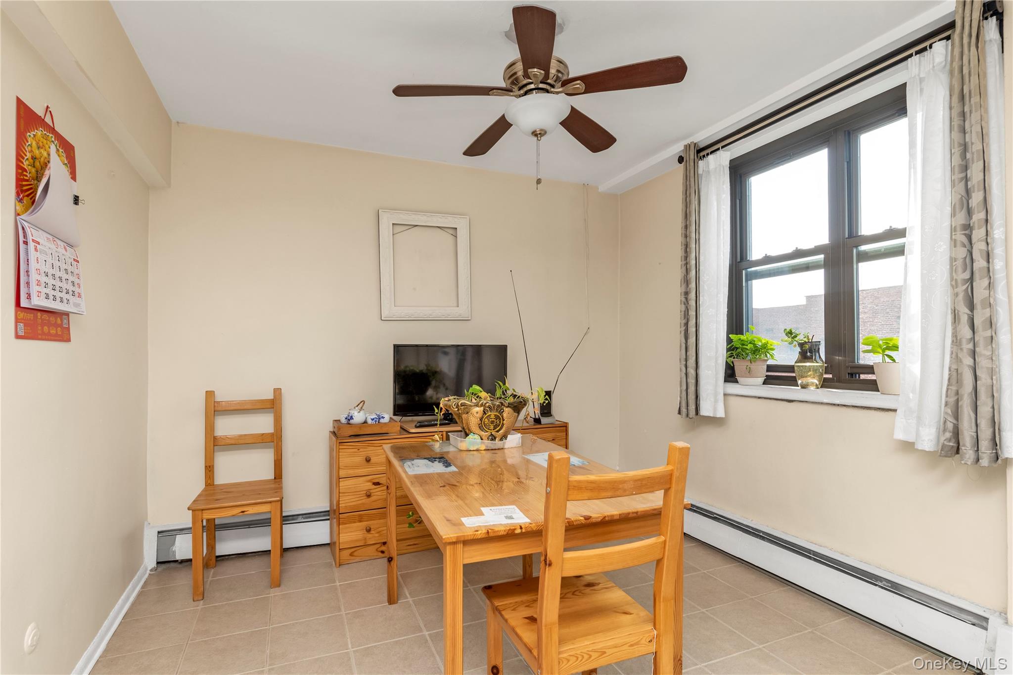 99-05 59th Avenue, Unit 6B Queens, NY 11368 - Photo 6 of 15 a dining room with furniture a floor to ceiling window and a ceiling fan