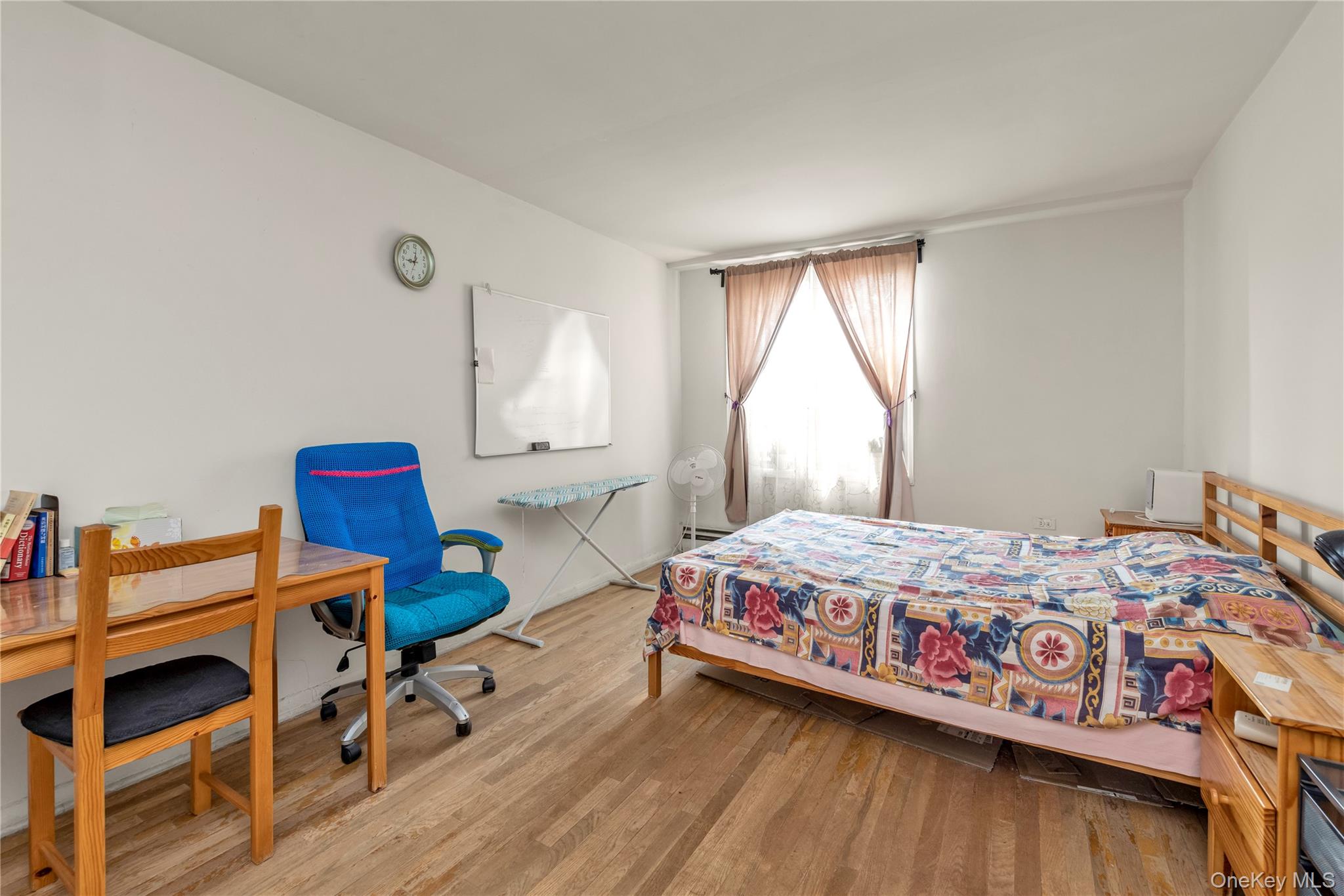 99-05 59th Avenue, Unit 6B Queens, NY 11368 - Photo 10 of 15 a bedroom with a bed and a wooden floor