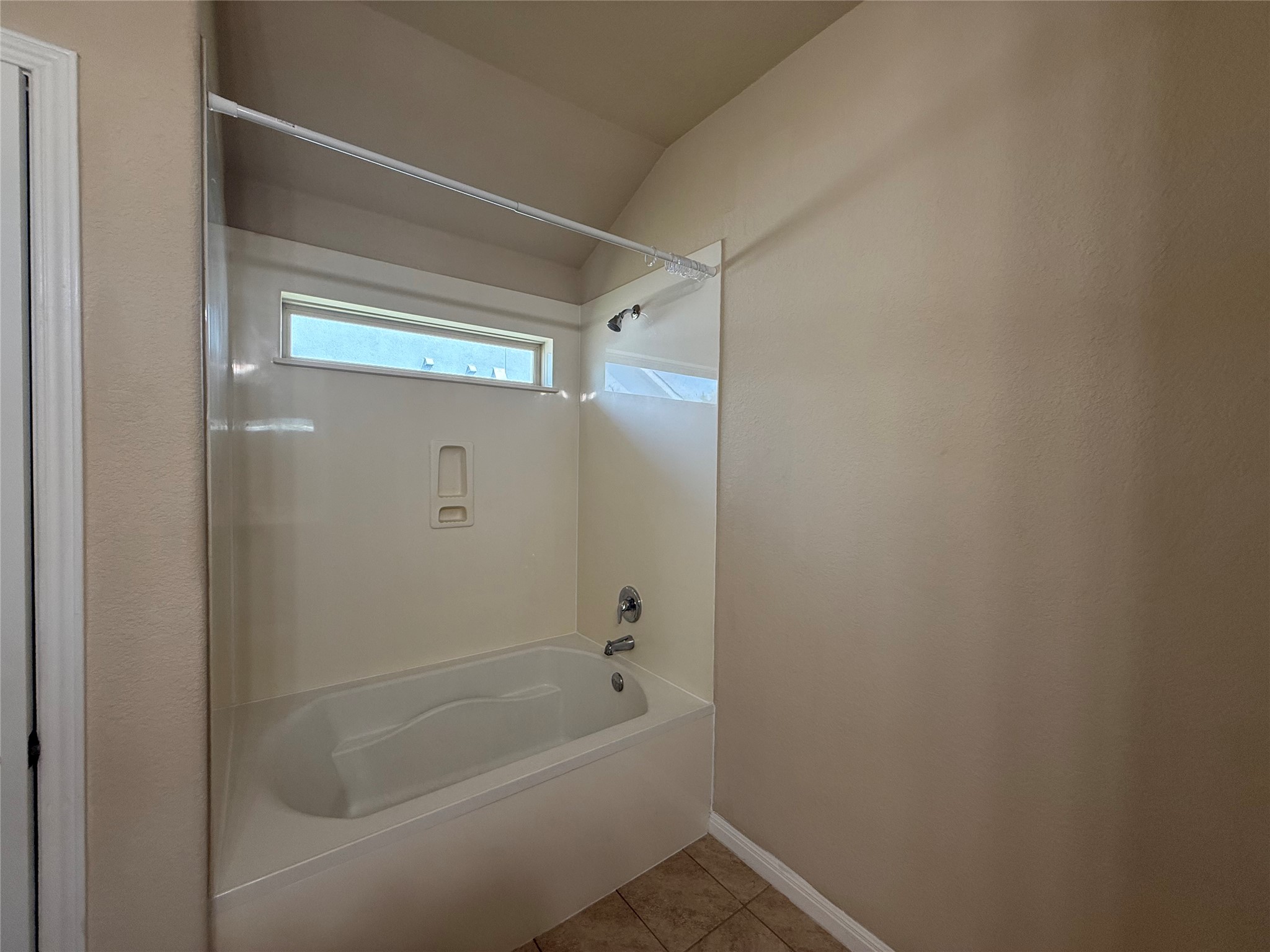 1441 Hamiltons Way Leander, TX 78641 - Photo 13 of 20 Full bath with shower / washtub combination, light tile patterned flooring, and lofted ceiling