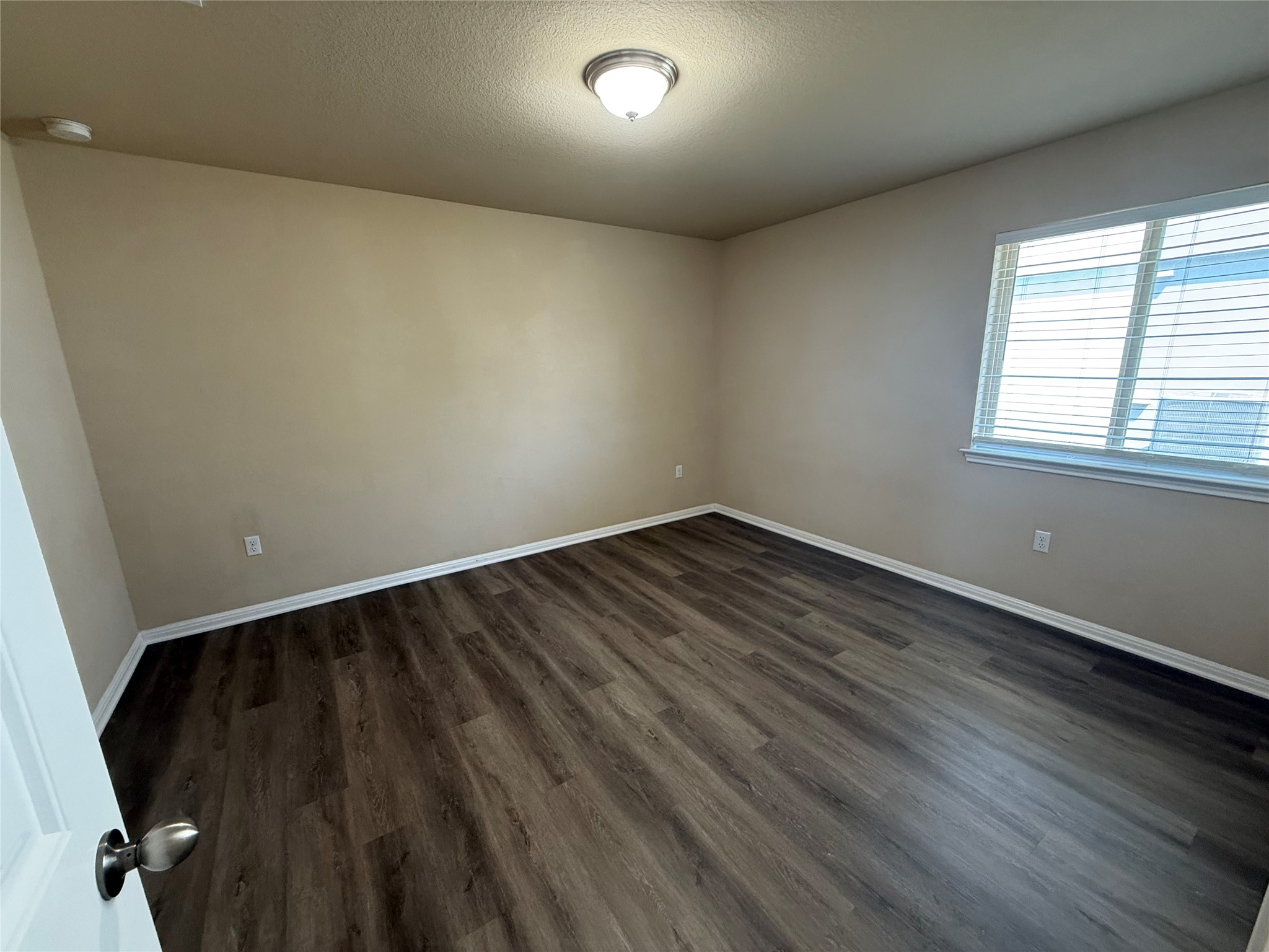 1441 Hamiltons Way Leander, TX 78641 - Photo 4 of 20 Spare room featuring dark wood-type flooring, a textured ceiling, and a smoke detector