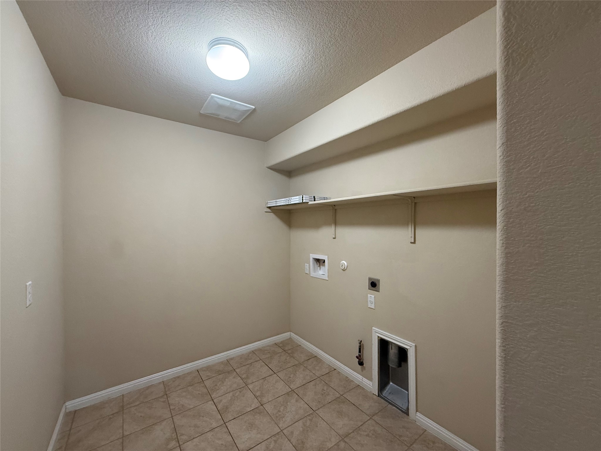 1441 Hamiltons Way Leander, TX 78641 - Photo 9 of 20 Laundry area with hookup for a gas dryer, a textured ceiling, washer hookup, and light tile patterned floors