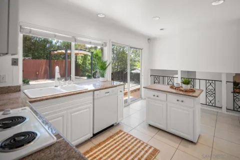 a kitchen with granite countertop white cabinets and a stove