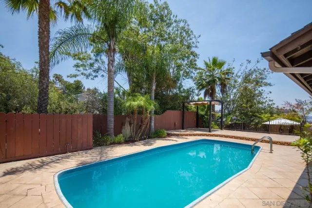 a view of a backyard with plants and wooden fence