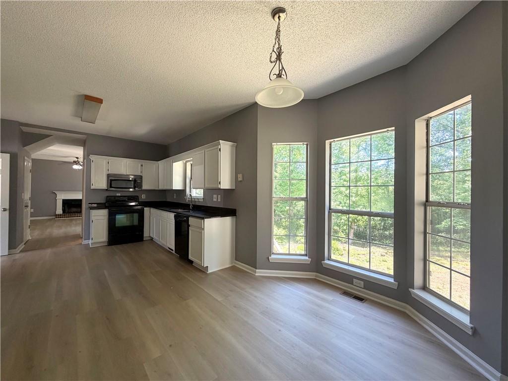 2205 Springer Walk Lawrenceville, GA 30043 - Photo 7 of 26 a large kitchen with stainless steel appliances granite countertop a large center island and a wooden floors