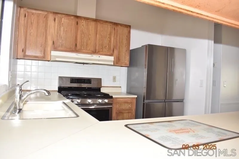 2515 Sweetwater Road, Unit 81 Spring Valley, CA 91977 - Photo 7 of 24 a kitchen with granite countertop a refrigerator stove and sink
