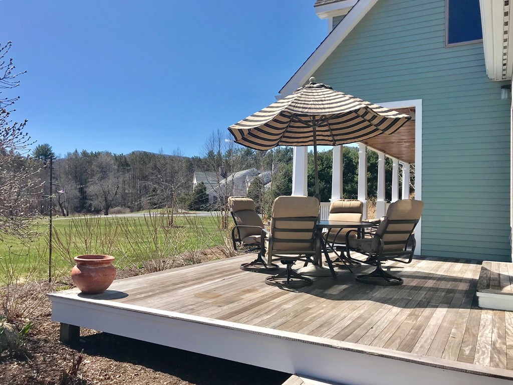 9 Swallow Farms Road Amherst, MA 01002 - Photo 3 of 30 a view of a patio with table and chairs with wooden floor and fence