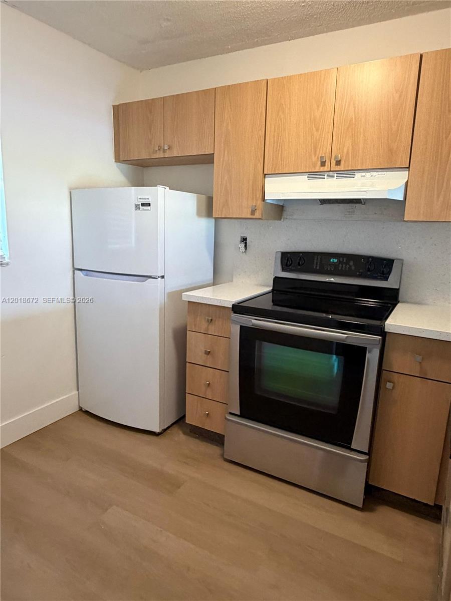 3400 Foxcroft Road, Unit 107 Miramar, FL 33025 - Photo 3 of 15 a kitchen with a stove a sink and a refrigerator