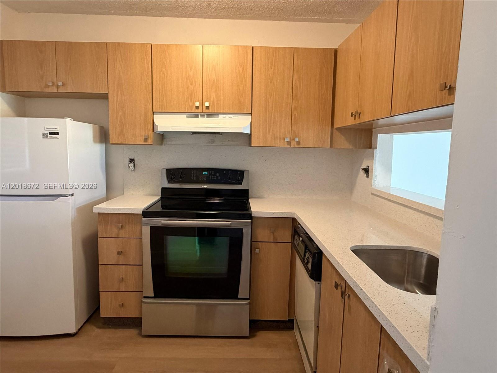 3400 Foxcroft Road, Unit 107 Miramar, FL 33025 - Photo 4 of 15 a kitchen with a sink stove and cabinets