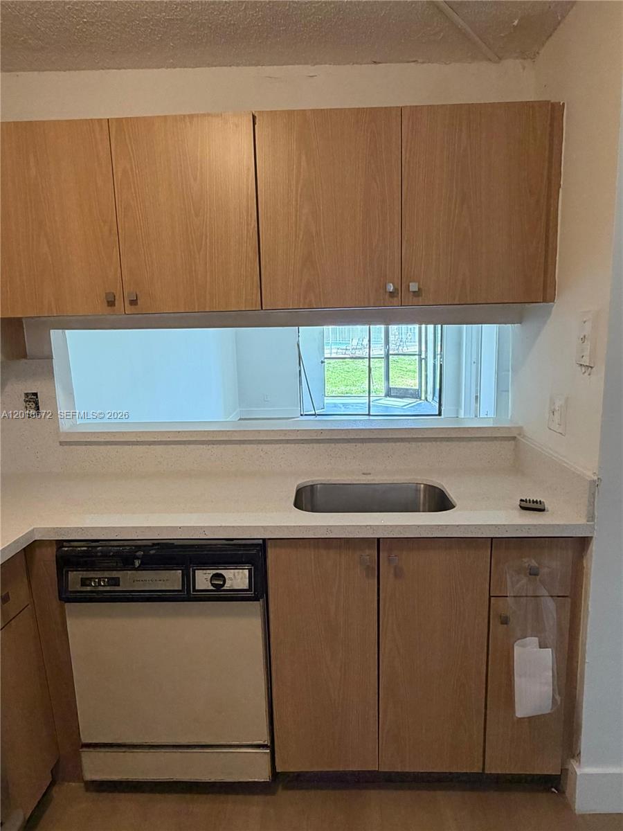 3400 Foxcroft Road, Unit 107 Miramar, FL 33025 - Photo 5 of 15 a kitchen with a sink a cabinetry and appliances