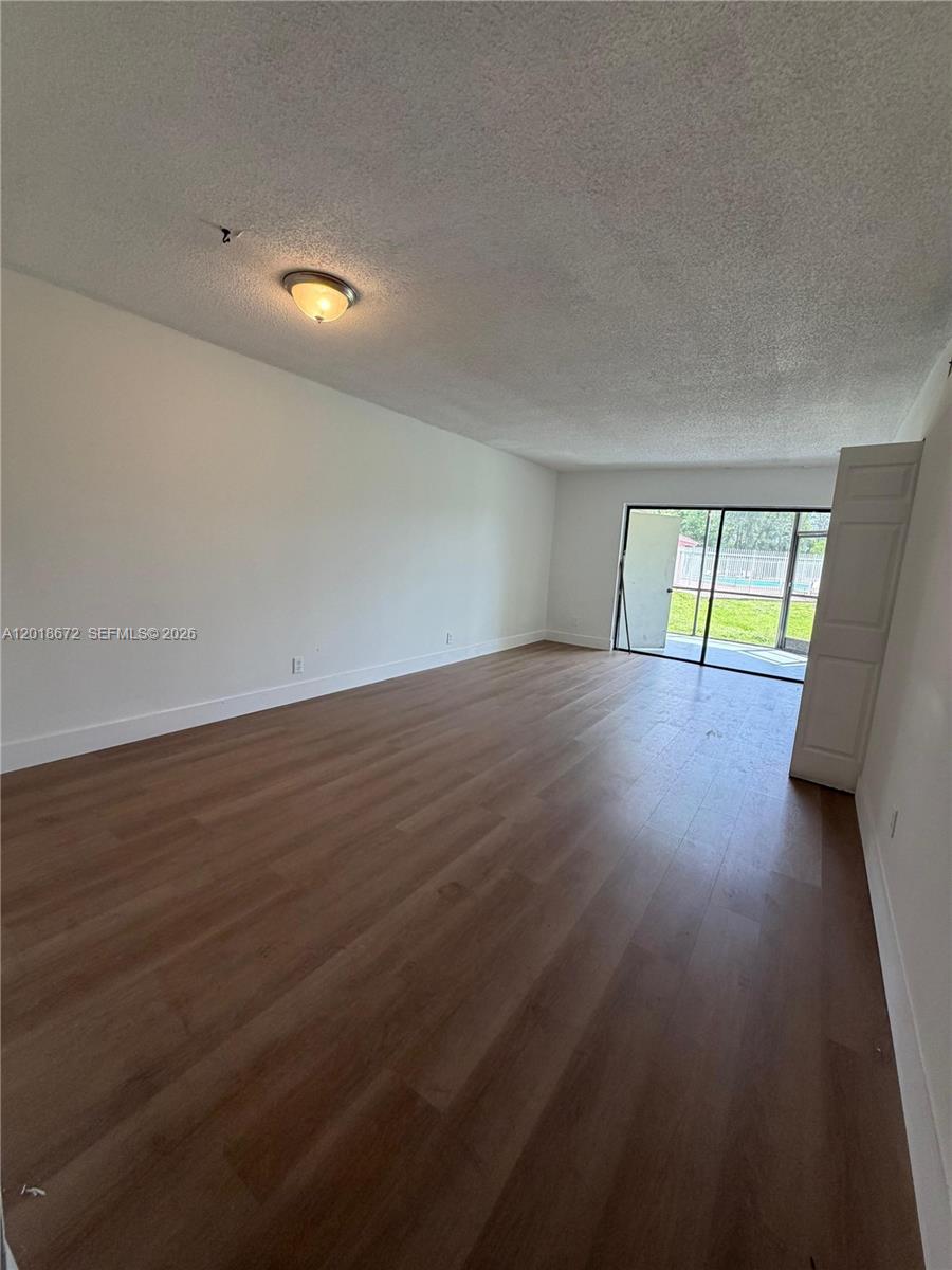 3400 Foxcroft Road, Unit 107 Miramar, FL 33025 - Photo 6 of 15 a view of an empty room with wooden floor and a window