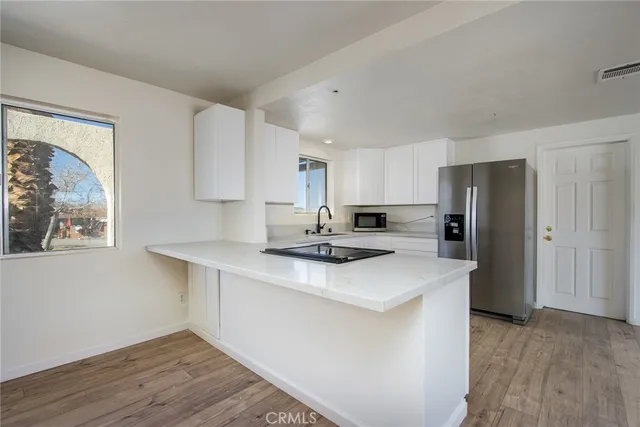 a kitchen with stainless steel appliances a sink a stove a refrigerator and cabinets