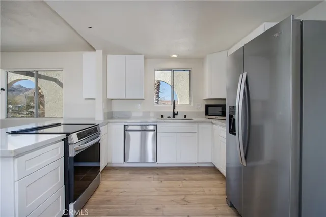 a kitchen with a refrigerator sink and stove top oven