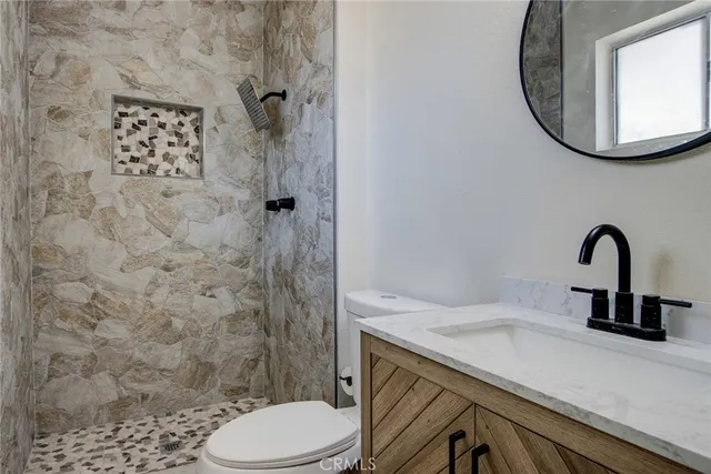 a bathroom with a sink a toilet and shower