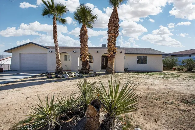 a front view of a house with yard and mountain view