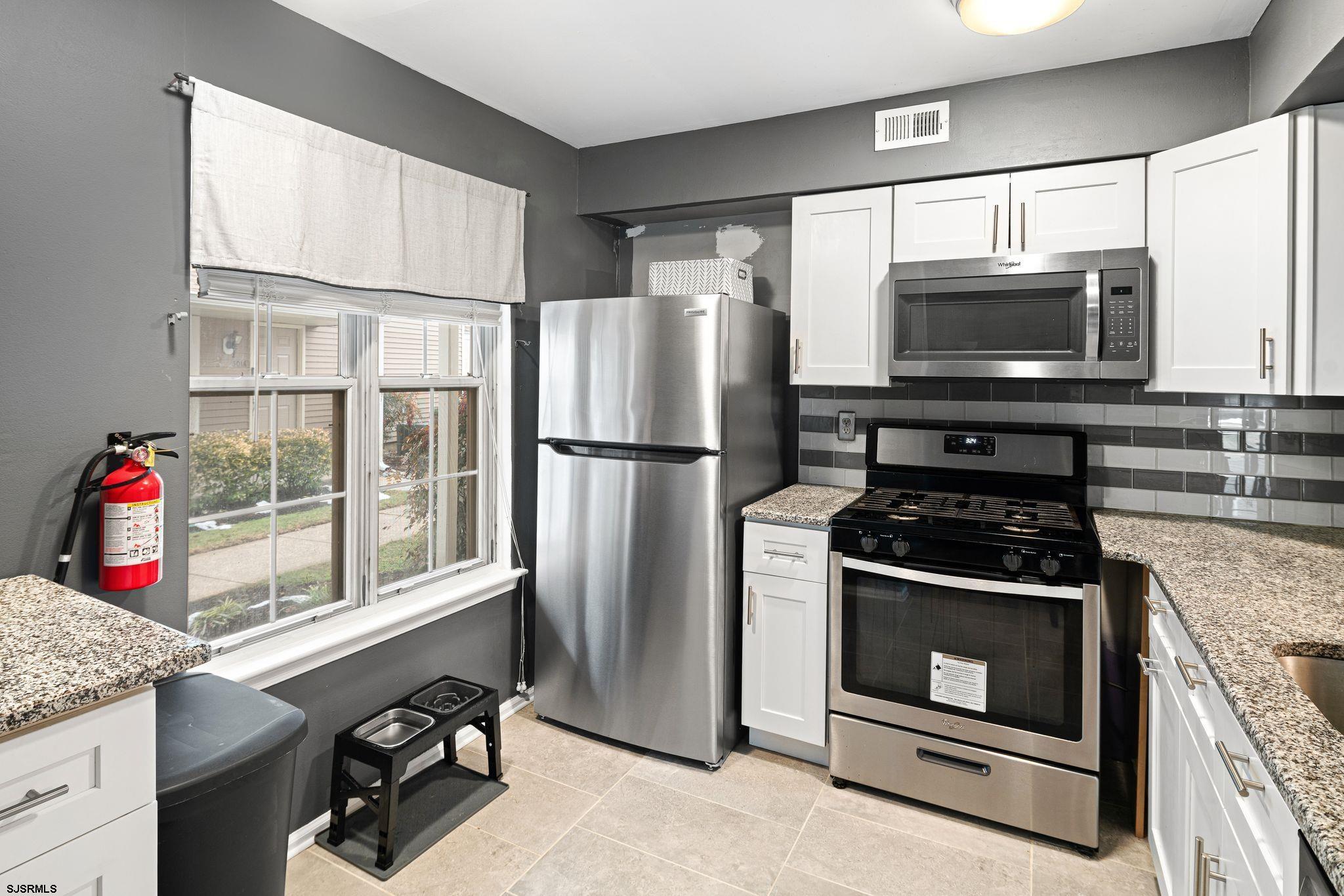 505 A Ralston Drive, Unit A Mount Laurel, NJ 08054 - Photo 2 of 18 a kitchen with granite countertop a stove a microwave a refrigerator and a sink