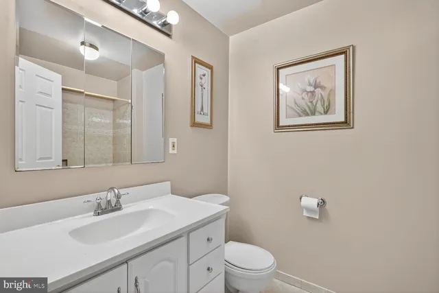 a bathroom with a toilet a sink and mirror