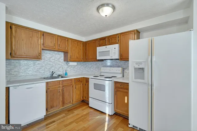 a kitchen with stainless steel appliances granite countertop a stove a sink dishwasher and a refrigerator