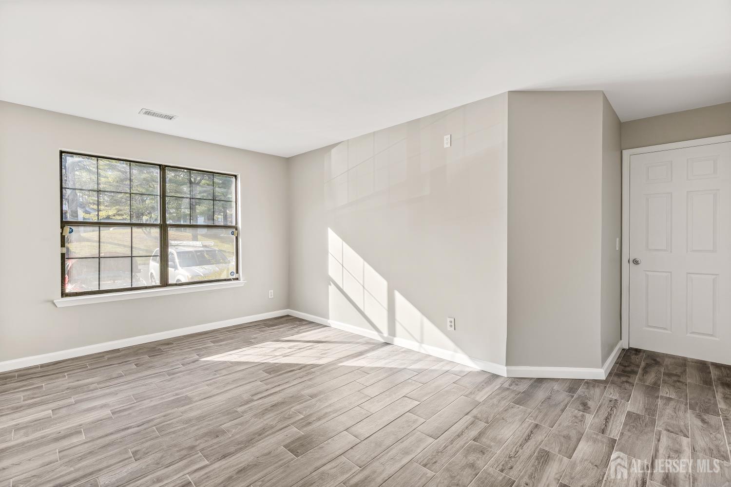 2301 Bayhead Drive Parlin, NJ 08859 - Photo 7 of 18 an empty room with wooden floor and windows
