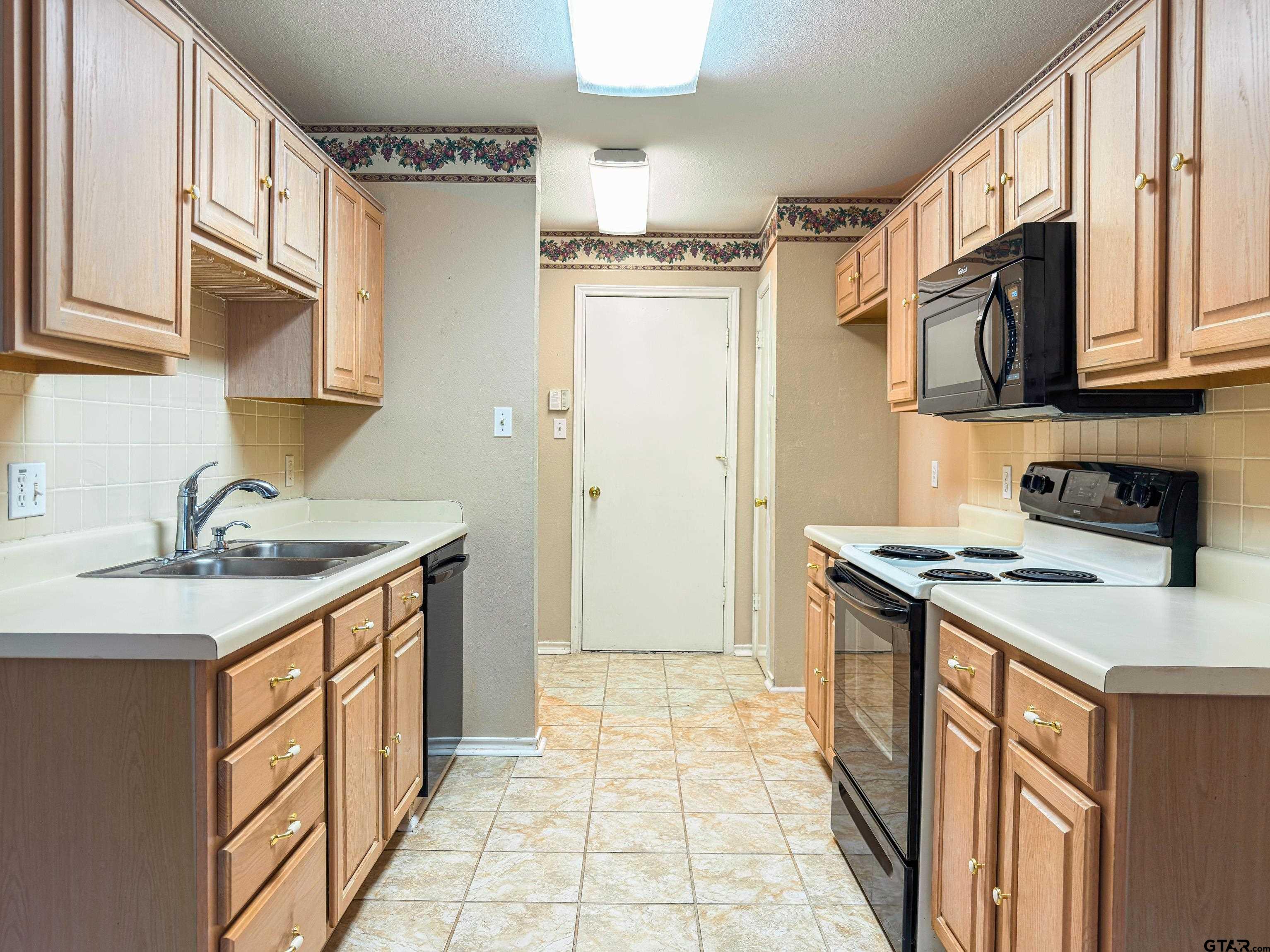 1202 Rice Road, Unit 112 Tyler, TX 75703 - Photo 3 of 12 a kitchen with stainless steel appliances granite countertop a sink stove and refrigerator