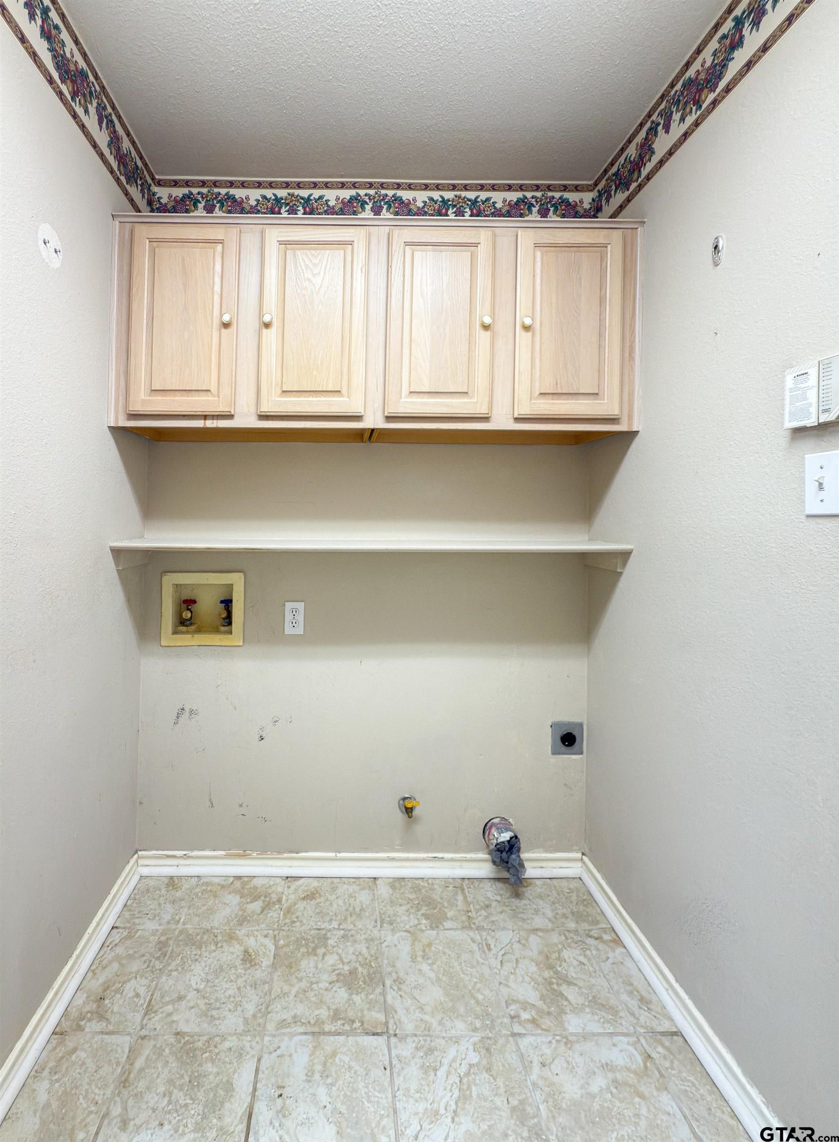 1202 Rice Road, Unit 112 Tyler, TX 75703 - Photo 5 of 12 a view of a kitchen with white cabinets and a window