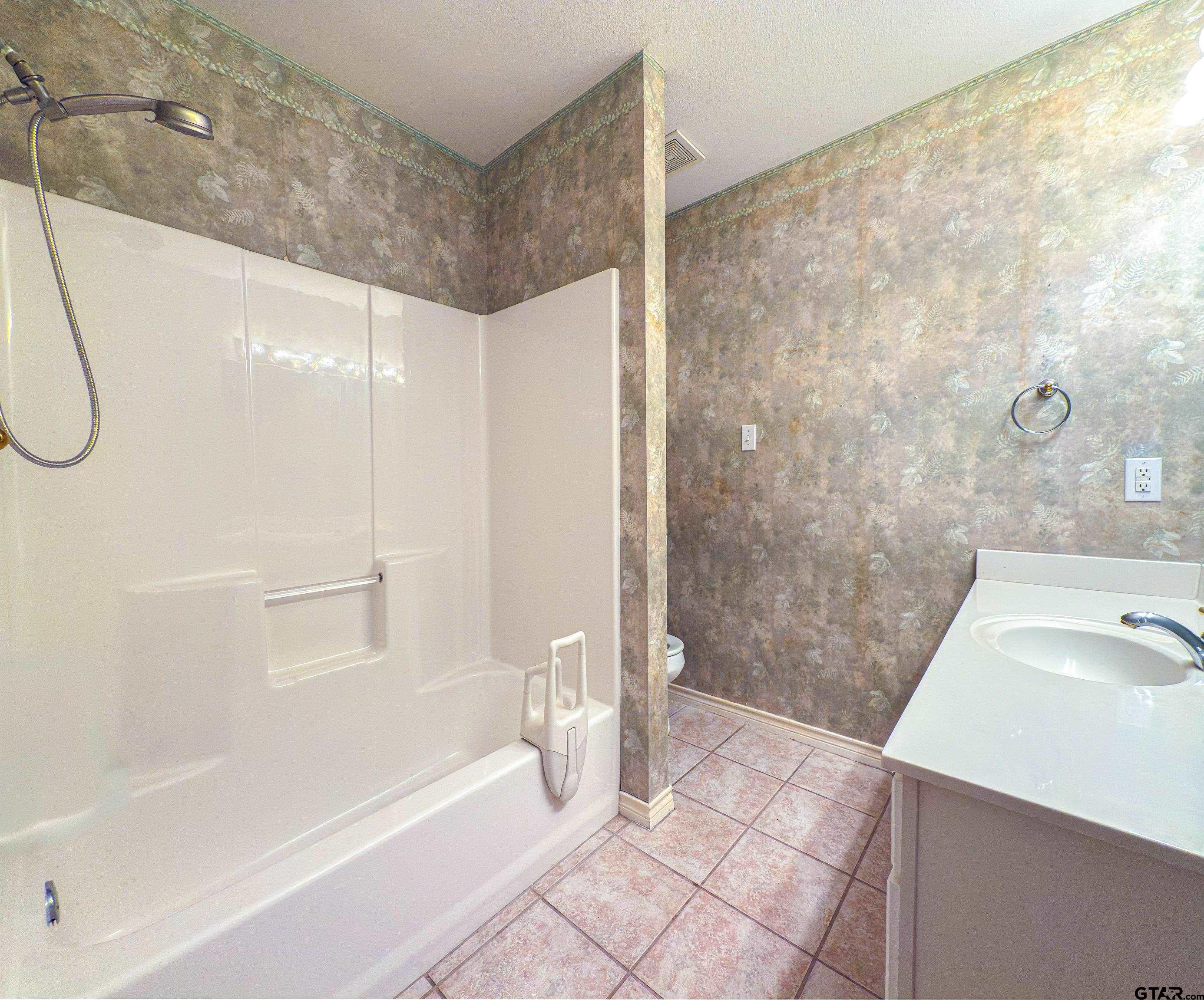 1202 Rice Road, Unit 112 Tyler, TX 75703 - Photo 9 of 12 a bathroom with a sink a toilet and shower