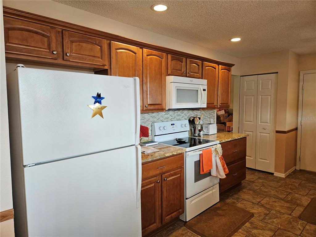 8480 Southwest 61st Terrace Road Ocala, FL 34476 - Photo 6 of 26 a kitchen with stainless steel appliances granite countertop a refrigerator a stove a sink a microwave and cabinets
