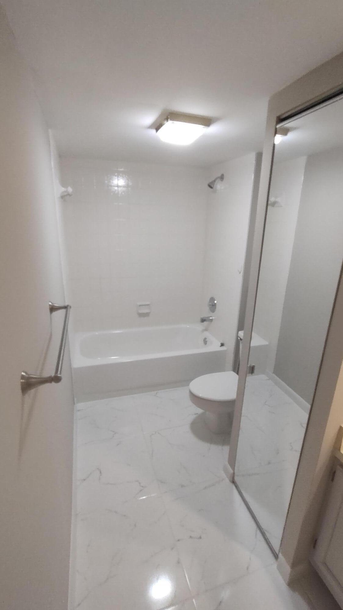 5646 Southeast Windsong Lane, Unit 415 Stuart, FL 34997 - Photo 14 of 20 a bathroom with a tub and a sink