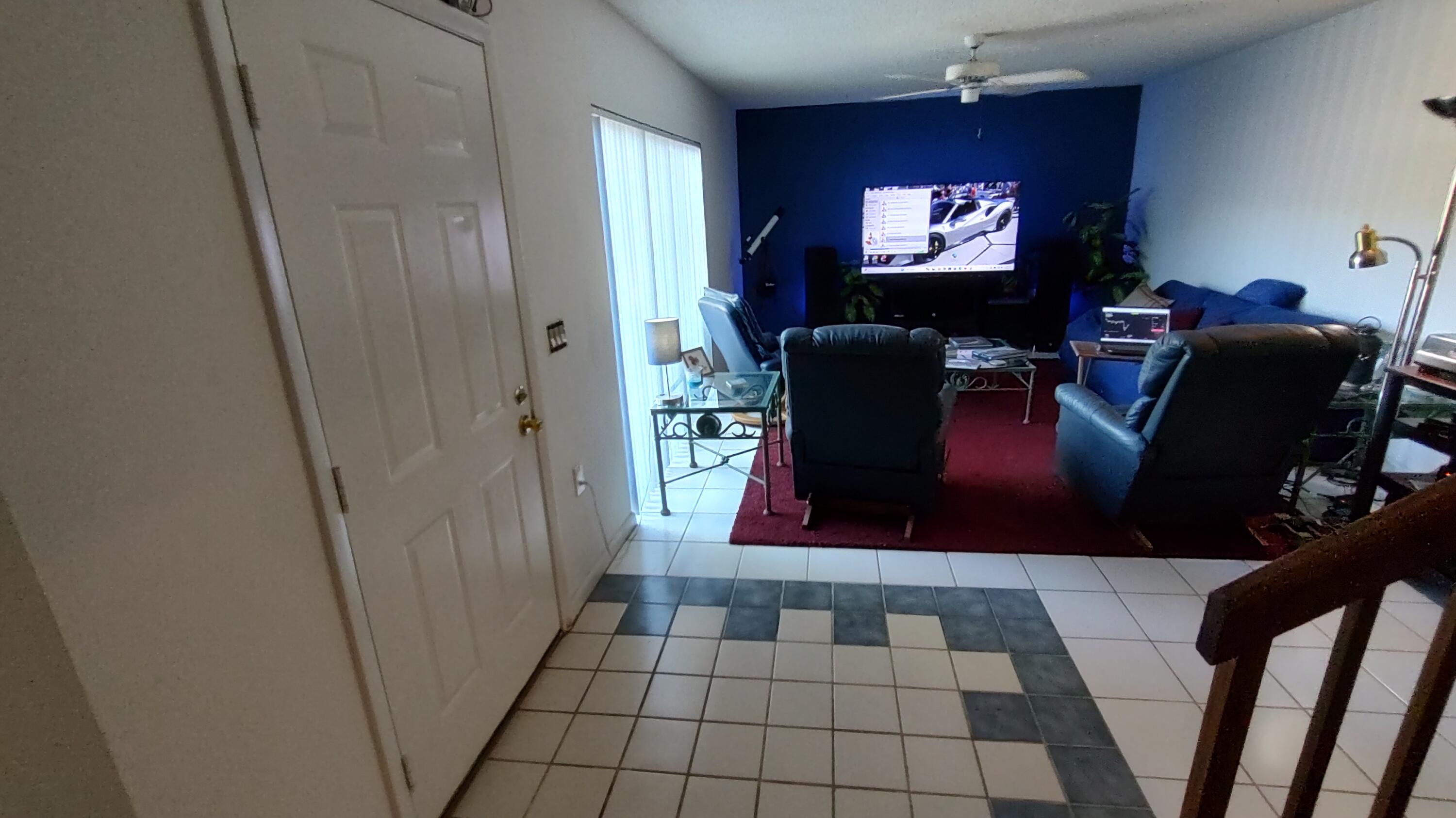 5646 Southeast Windsong Lane, Unit 415 Stuart, FL 34997 - Photo 4 of 20 a view of a living room with furniture and a flat screen tv