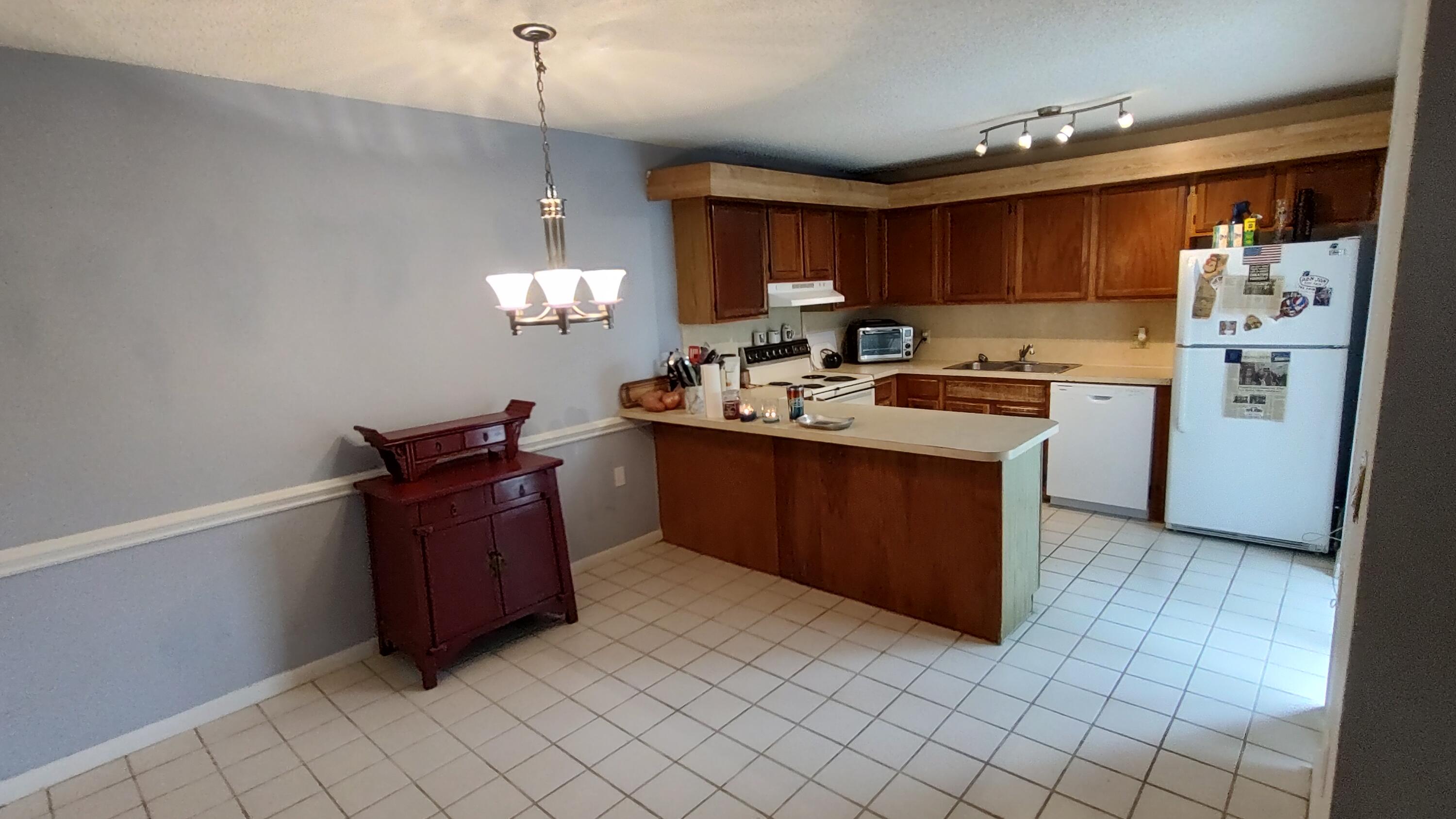 5646 Southeast Windsong Lane, Unit 415 Stuart, FL 34997 - Photo 5 of 20 a kitchen with stainless steel appliances granite countertop a sink stove and refrigerator