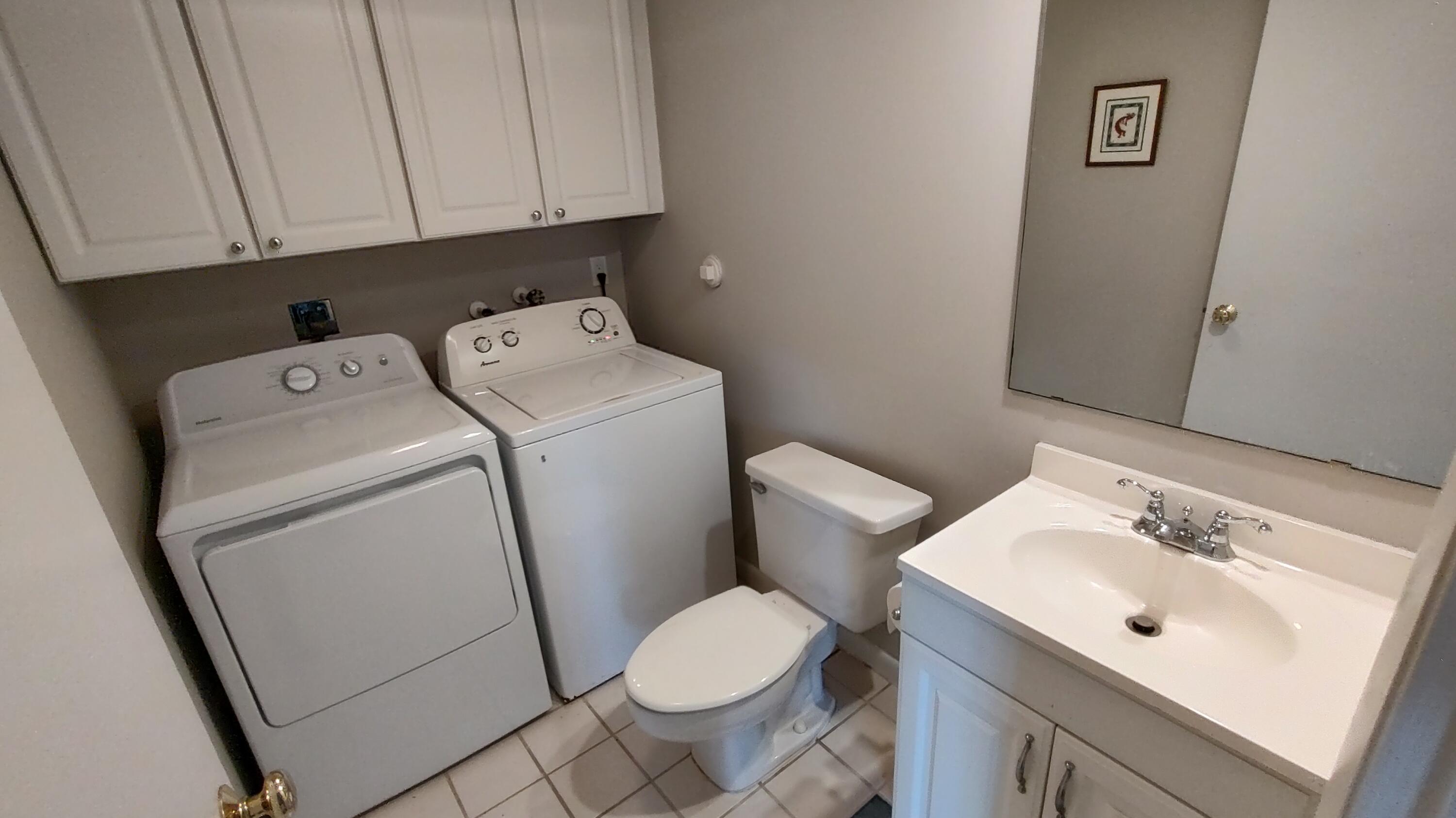 5646 Southeast Windsong Lane, Unit 415 Stuart, FL 34997 - Photo 6 of 20 a bathroom with a sink toilet and vanity