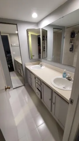 a bathroom with double sink and a mirror
