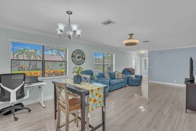 a view of a dining room with furniture a chandelier and wooden floor