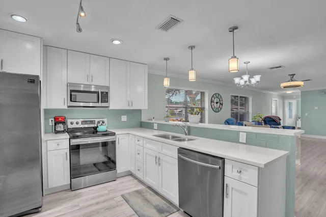 a kitchen with kitchen island a sink stainless steel appliances and cabinets