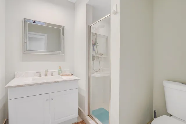 a bathroom with a toilet sink vanity and mirror