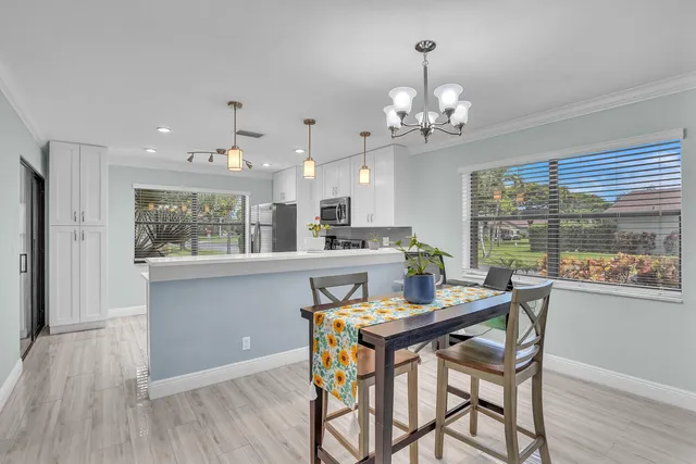 a dining room filled chandelier and wooden floor