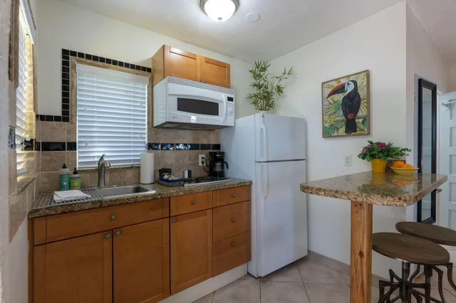 a kitchen with stainless steel appliances granite countertop a sink and a refrigerator