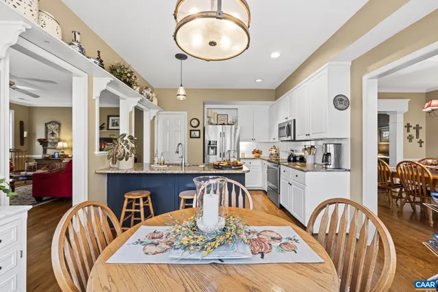 a kitchen with stainless steel appliances granite countertop a dining table chairs stove a sink and dishwasher