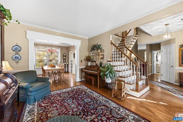 a living room with furniture a rug and a dining table